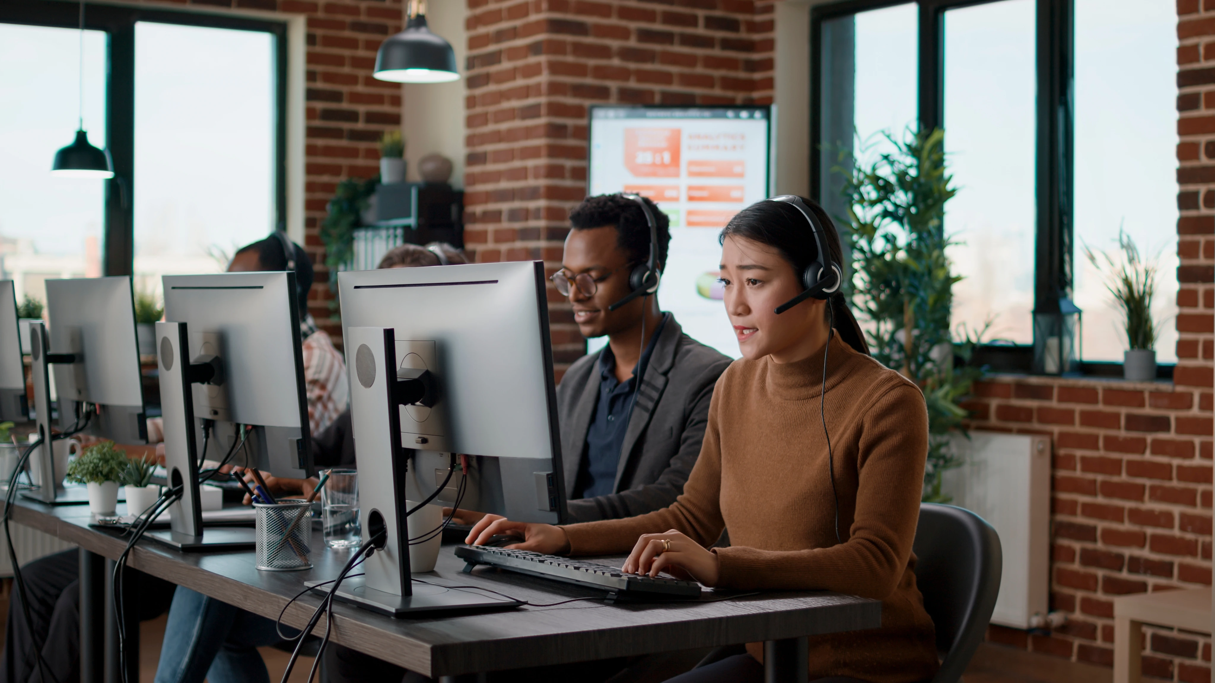Equipe de atendimento trabalhando com headsets em escritório